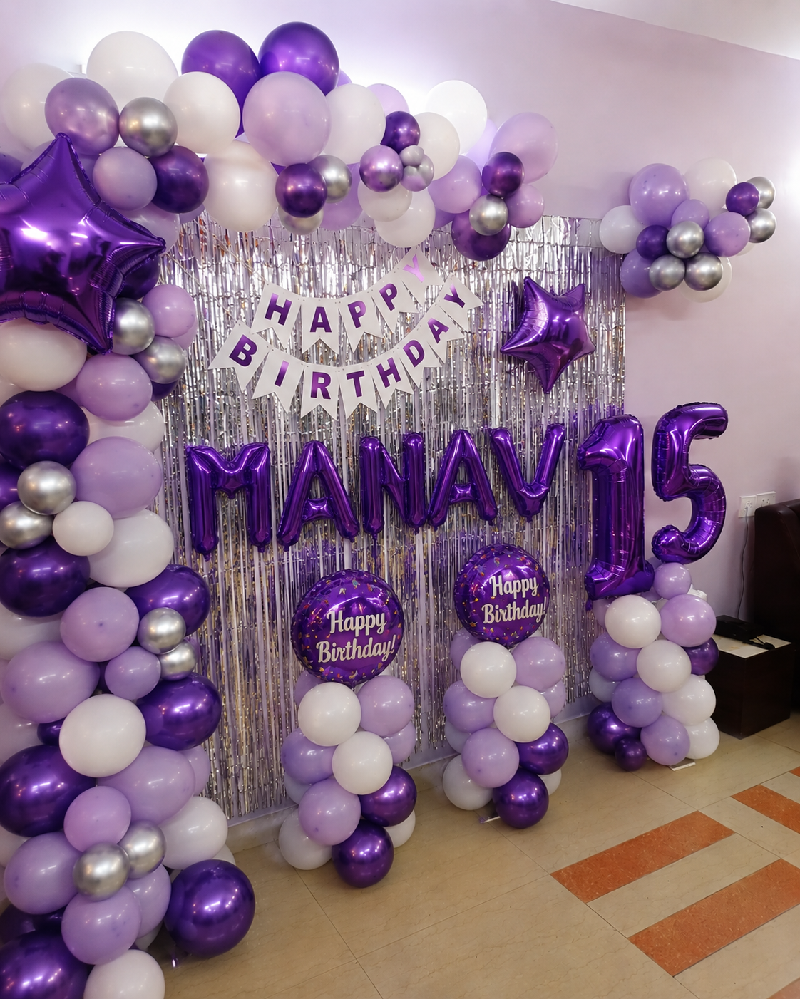 Purple birthday decoration with foil name balloons and number setup