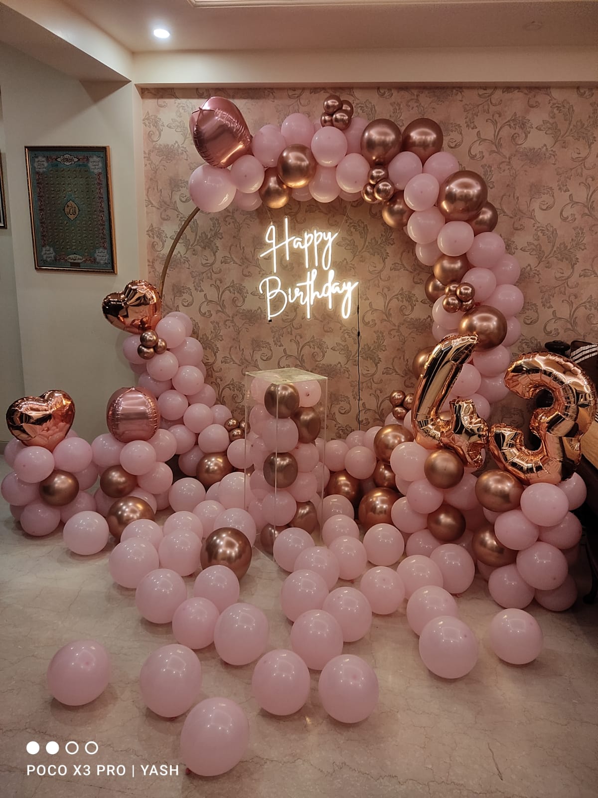 Rose gold birthday balloon arch with neon sign and number balloons